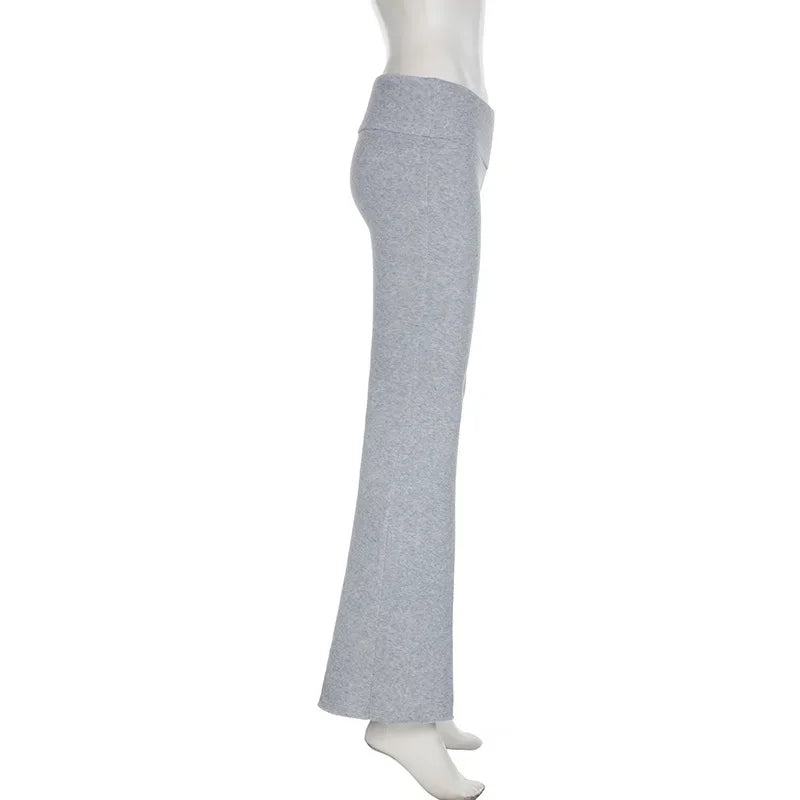 Pantalon flare Y2K taille basse pour femme, style bootcut slim casual sexy, en denim bleu, porté avec haut tendance.