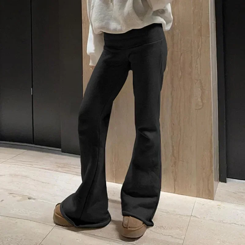 Pantalon flare Y2K taille basse pour femme, style bootcut slim casual sexy, en denim bleu, portant un look tendance 2024.